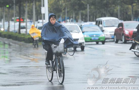 10月14日，市民在市區(qū)東方紅路雨中騎行。